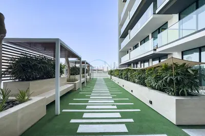 an office building with a walkway with plants at Studio Near Dubai Autodrome & Trump Golf Club, Binghatti Amber, JVC By Deluxe Holiday Homes in Dubai