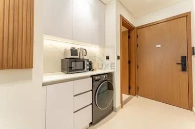 a kitchen with a washer and dryer on a counter at Studio Near Dubai Autodrome & Trump Golf Club, Binghatti Amber, JVC By Deluxe Holiday Homes in Dubai