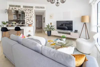 a living room with a blue couch and a tv at Frank Porter - Saba 3 in Dubai