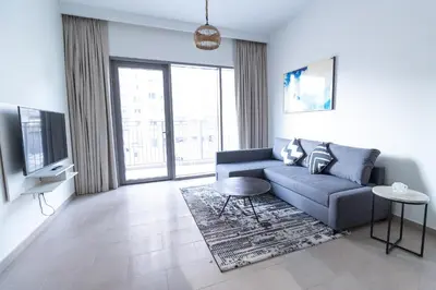 a living room with a blue couch and a tv at Park Heights 2 Dubai Hills 1BR by Happy Season in Dubai
