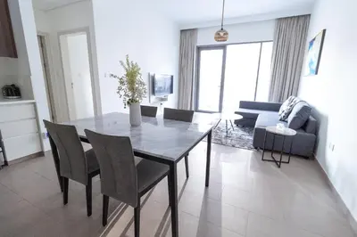 a dining room with a table and chairs and a couch at Park Heights 2 Dubai Hills 1BR by Happy Season in Dubai