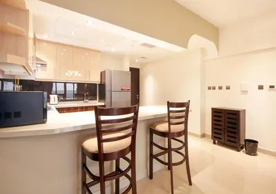 a kitchen with two bar stools and a refrigerator at Luxury 2BR Apartment in Downtown Dubai Elite Stay in Dubai