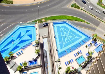 an overhead view of two swimming pools next to a road at Luxury 2BR Apartment in Downtown Dubai Elite Stay in Dubai