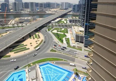 a bridge over a highway in a city with cars at Luxury 2BR Apartment in Downtown Dubai Elite Stay in Dubai
