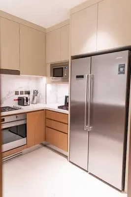 a kitchen with a stainless steel refrigerator at ADDRESS Residences Dubai Opera at Downtown in Dubai