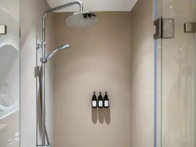 a shower with three bottles of wine in a bathroom at Luxury 1-BR Escape in Dubai Hills Collective , 5 min from Mall in Dubai