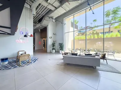 a large room with tables and chairs and a large window at Luxury 1-BR Escape in Dubai Hills Collective , 5 min from Mall in Dubai
