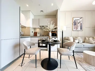 a kitchen and living room with a table and chairs at Trophy-Live in Style Artistic Flair Unit in Dubai