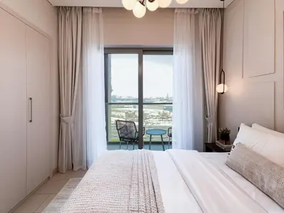 a bedroom with a bed and a large window at Trophy-Live in Style Artistic Flair Unit in Dubai