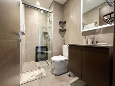 a bathroom with a toilet and a glass shower at Trophy-Live in Style Artistic Flair Unit in Dubai