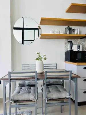a dining room table with two chairs and a mirror at Fully-equipped 1-br in Dubai Hills great amenities in Dubai
