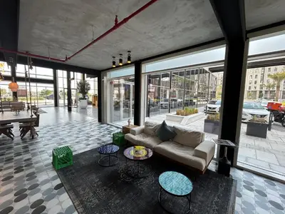 a living room with a couch and tables and windows at Fully-equipped 1-br in Dubai Hills great amenities in Dubai