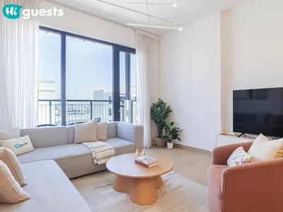 a living room with a couch and a tv and a table at HiGuests - La Rive Living Classy 2BR with Balcony in Dubai