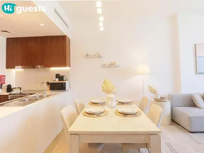 a kitchen and dining room with a table and chairs at HiGuests - La Rive Living Classy 2BR with Balcony in Dubai
