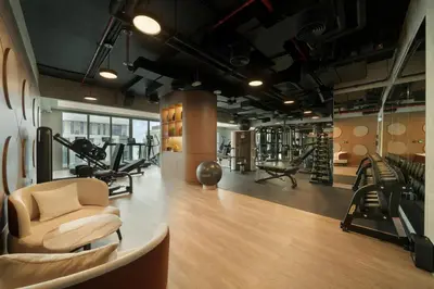 a gym with several treadmills and chairs in a room at Mileo Hotel The Palm in Dubai