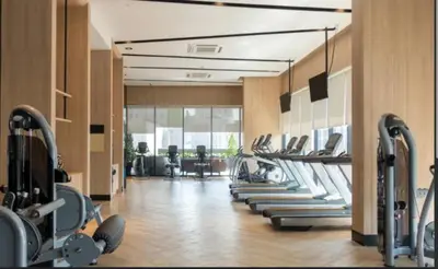 a gym with a row of treadms and machines at Modern Luxury Fully Furnished 1BH Apartment in Binghatti Luna JVC - Easy Access to JBR, Circle Mall & Dubai Hills Mall in Dubai