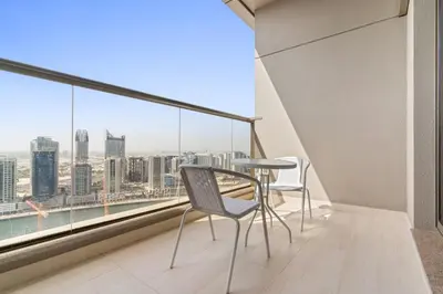 a balcony with a table and chairs and a view of the city at Cozy Studio in Downtown Dubai in Dubai
