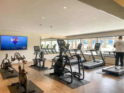 a man standing in a gym with several tread machines at Cozy Studio in Downtown Dubai in Dubai