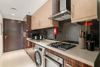 a kitchen with a stove top oven next to a dishwasher at Cozy Studio in Downtown Dubai in Dubai