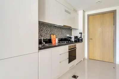 a kitchen with white cabinets and a stove top oven at GuestReady - Luxury Oasis in Business Bay in Dubai