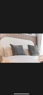 a white bed with gray pillows on it at Modern 2 BDR Apartment in Business Bay, Ocean & Burj AlArab Stunning View in Dubai