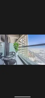 a balcony with chairs and a plant on a building at Modern 2 BDR Apartment in Business Bay, Ocean & Burj AlArab Stunning View in Dubai