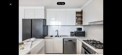 a white kitchen with a sink and a stove at Luxurious Downtown Views 2 bedrooms holiday home in Dubai