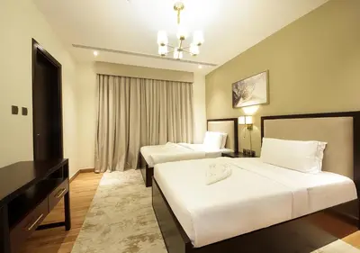 a hotel room with two beds and a desk at Downtown Dubai Stay in 2BR Chic Elite Apartment in Dubai