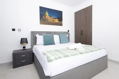 a bedroom with a large bed and a nightstand at Spacious 2BR Apartment l Rooftop Pool l Gym in Dubai