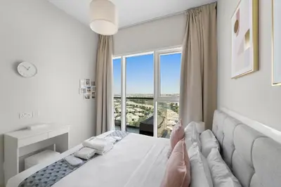 a bedroom with a bed with a large window at Modern 1BR at Golf Vita A in Damac Hills Near Golf in Dubai