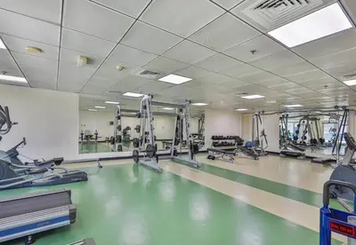 a gym with a swimming pool and tread machines at Near Metro Station - 1BR in Marina Diamond 3, Dubai Marina - Allsopp & Allsopp in Dubai