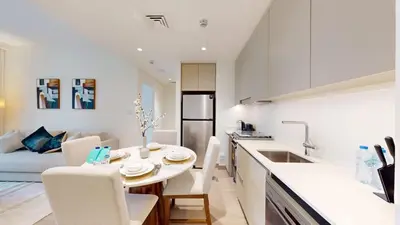 a kitchen and living room with a table and chairs at FAM Living - Modern 1BR at Orchid, Creek Harbour in Dubai