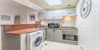 a kitchen with a washing machine and a sink at 8min Walk from JBR beach Stylish 1-Bedroom Apartment in Dubai Marina in Dubai