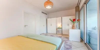 a bedroom with a bed and a vase of flowers at 8min Walk from JBR beach Stylish 1-Bedroom Apartment in Dubai Marina in Dubai