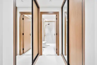 a mirror in a bathroom with a toilet and a sink at Vibrant - 2BR - Exclusive Pool, Shared Gym in Dubai