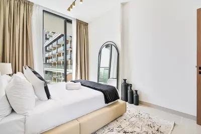 a white bedroom with a large bed and a mirror at Vibrant - 2BR - Exclusive Pool, Shared Gym in Dubai