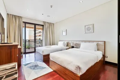 a hotel room with two beds and a balcony at Spacious 2 Bed Unit With Aquaventure Waterpark Views in Dubai