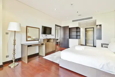 a white bedroom with a bed and a television at Spacious 2 Bed Unit With Aquaventure Waterpark Views in Dubai