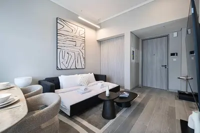 a living room with a couch and a table at Stylish 1BR with Spacious Terrace Near Circle Mall in Dubai