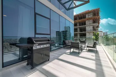 a kitchen with a grill on the balcony of a building at Stylish 1BR with Spacious Terrace Near Circle Mall in Dubai