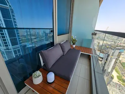 a balcony with a couch and a view of a city at New Renovated Stylish 1 Br Dubai View 73 Floor in Dubai