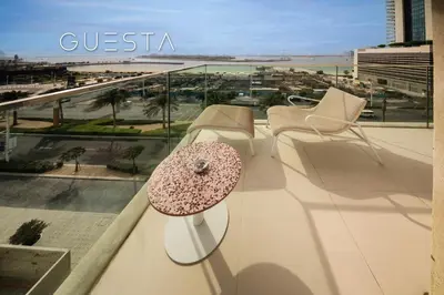 a table on a balcony with a view of the beach at Emaar Beachfront - Sunrise Bay Tower 1, Dubai Marina in Dubai