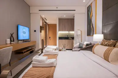 a living room with a large bed and a tv at Brand New Designer Studio - Urban Retreat in JVC in Dubai