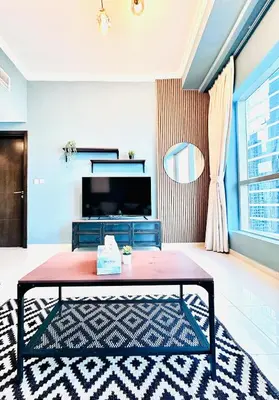 a living room with a coffee table and a tv at Bright and Modern Condo in Dubai Marina in Dubai