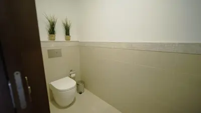 a bathroom with a toilet and two potted plants at Luxury 1BR Downtown Dubai Skyline & Sea View in Dubai