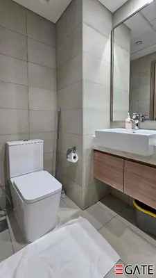 a bathroom with a toilet and a sink and a mirror at EGATE - Studio - 2nd Floor with Balcony - Dubai - 33-212 in Dubai