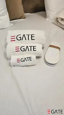 a pile of towels on a bed with a cell phone at EGATE - Studio - 2nd Floor with Balcony - Dubai - 33-212 in Dubai