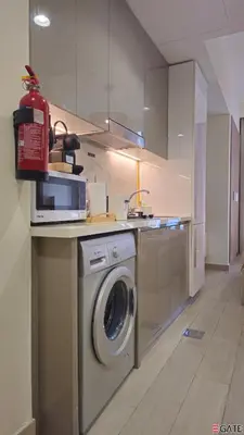 a kitchen with a washing machine under a counter at EGATE - Studio - 2nd Floor with Balcony - Dubai - 33-212 in Dubai