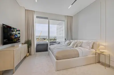 a bedroom with a large bed and a large window at Daniels Studio at Marasi Drive with Canal View in Dubai