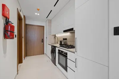 a kitchen with white counters and a stove top oven at Daniels Studio at Marasi Drive with Canal View in Dubai